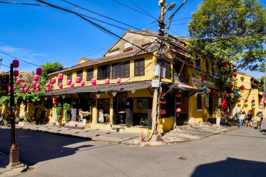 Hoi An travel guide: yellow shophouses hung with pink and red lanterns on a corner in the Old Town