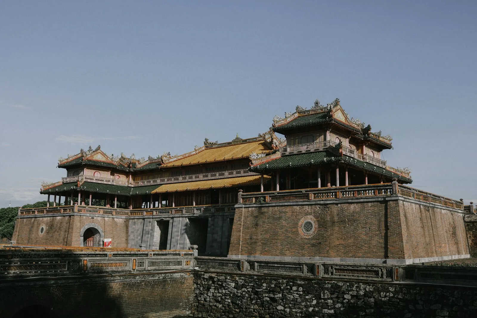 Side view of the Meridian Gate and the brick ramparts of the Hue Citadel rising above the moat