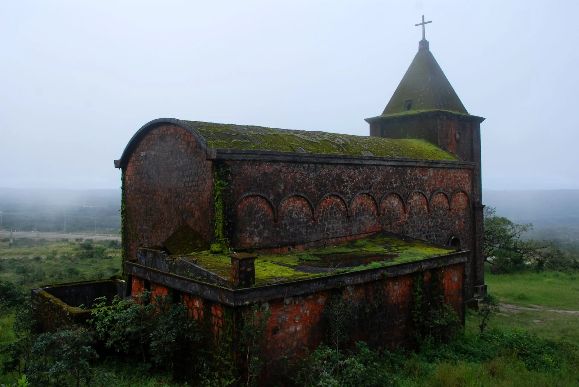 Moss-covered old Catholic church at Bokor Hill Station in mist, Bokor National Park