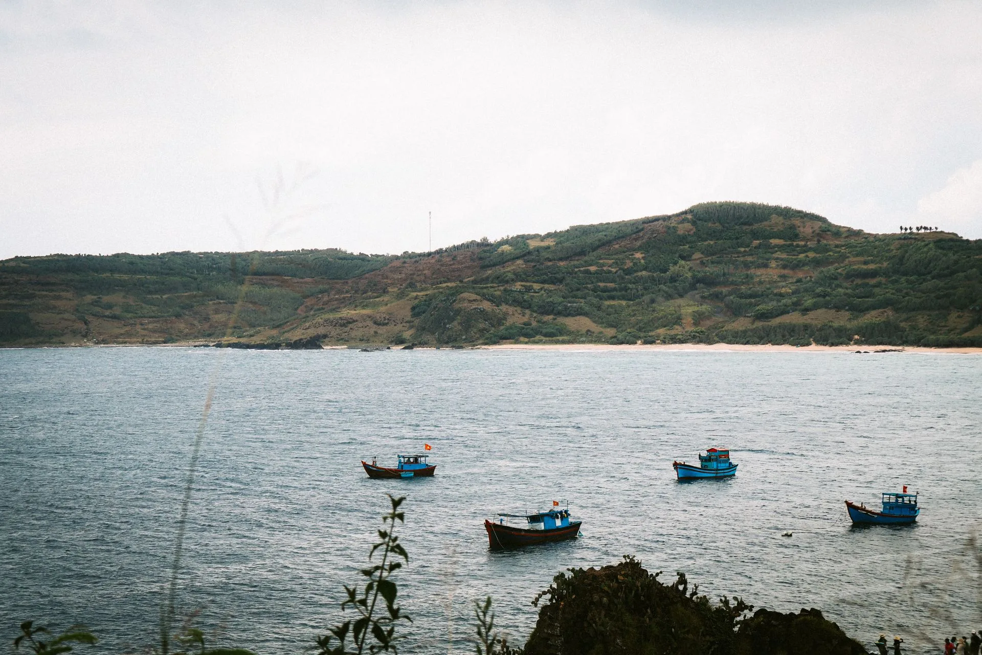 Small blue fishing boats moored in a quiet bay off Phu Yen