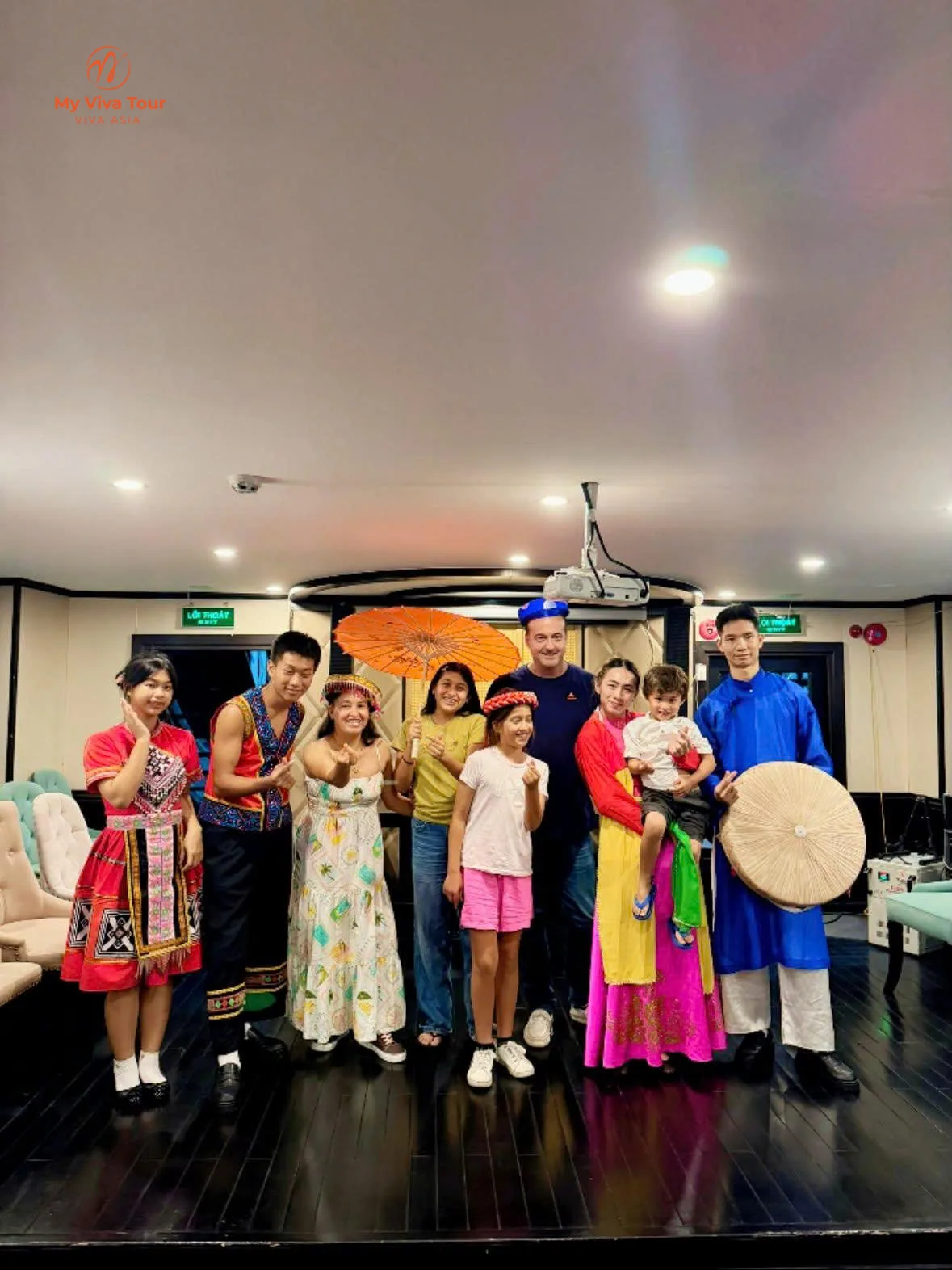 Family with the crew after a traditional costume show on a Ha Long Bay cruise