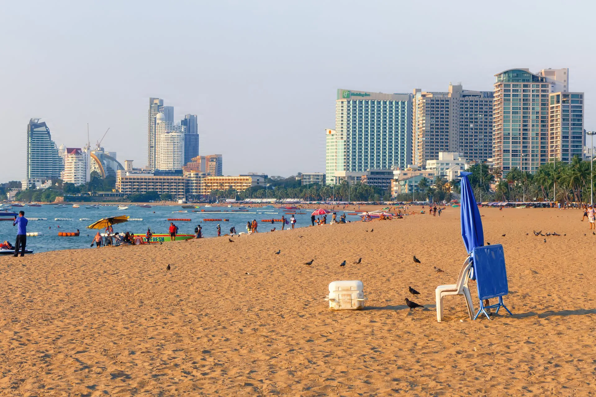 Pattaya Beach in the afternoon with golden sand, beach umbrellas and the city's high-rise hotels behind
