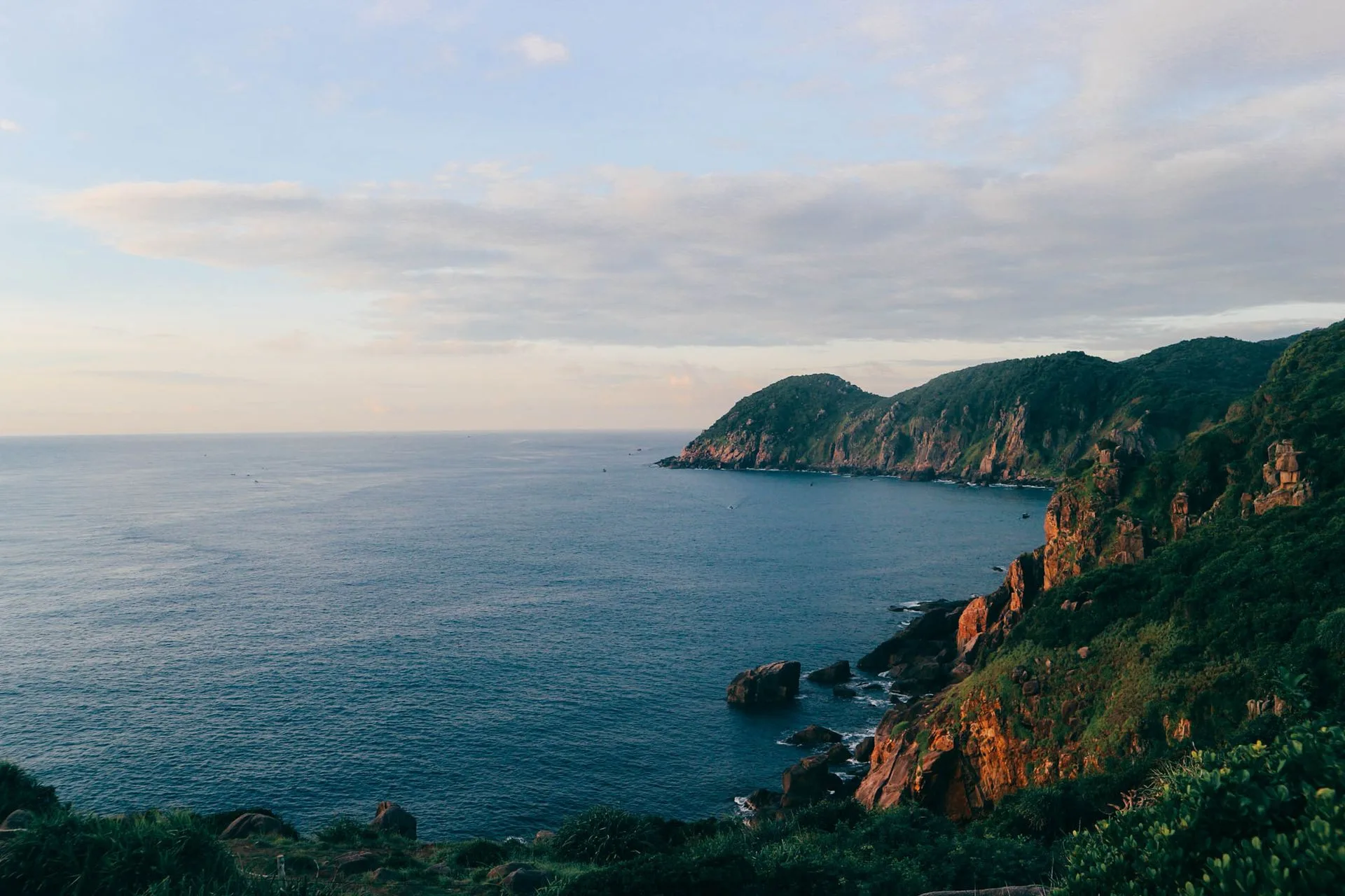 Green headlands and red cliffs above a calm bay on the Phu Yen coast