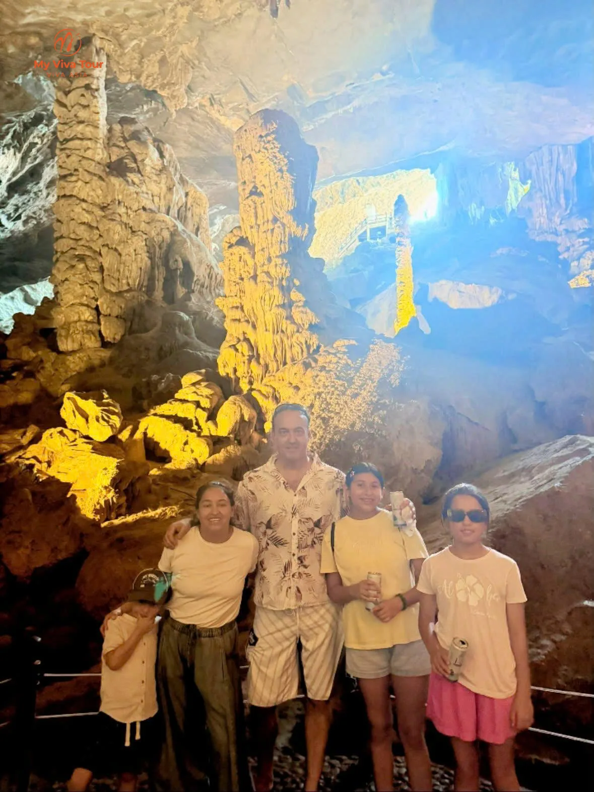 Family inside the lit chambers of Sung Sot Cave, Ha Long Bay
