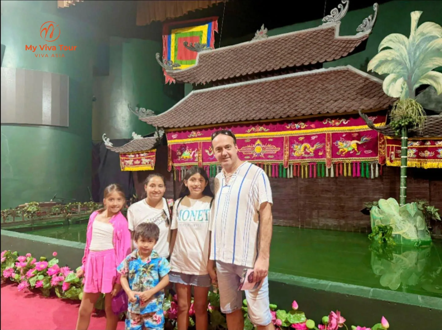 Family in front of a traditional Vietnamese water puppet stage